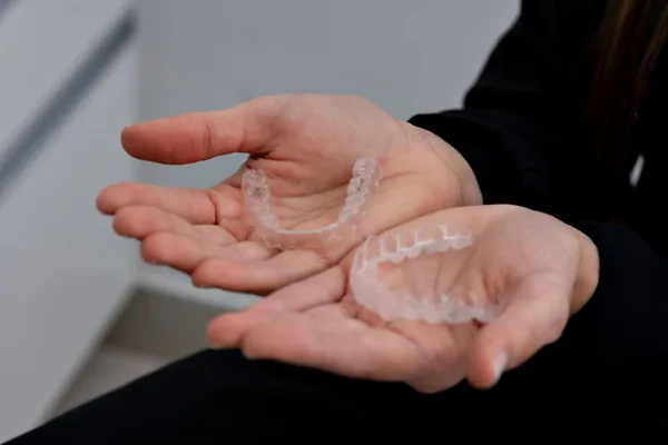 Átlátszó Invisalign sínek közelről, kézben